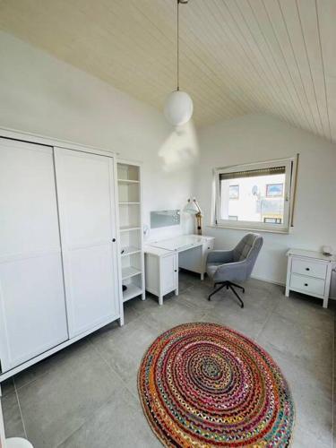 Zimmer mit einem Schreibtisch, einem Stuhl und einem Teppich in der Unterkunft appartme. XS in Bad Herrenalb