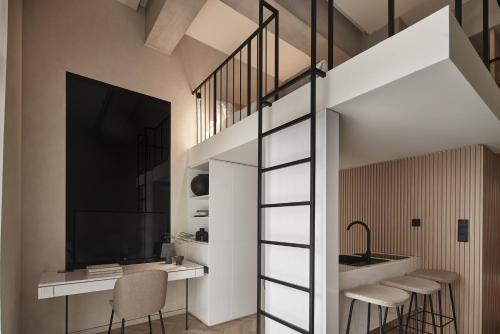 a room with a loft bed and a desk with chairs at The Newel Psychiko in Athens