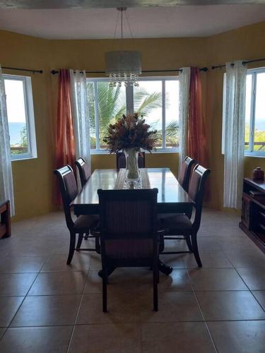 a dining room table with chairs and a vase of flowers at Bellevue hideaway in Gros Islet