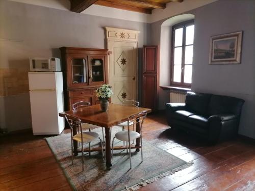 sala de estar con mesa y sofá en La locanda del Castello con terrazzo, en Susa