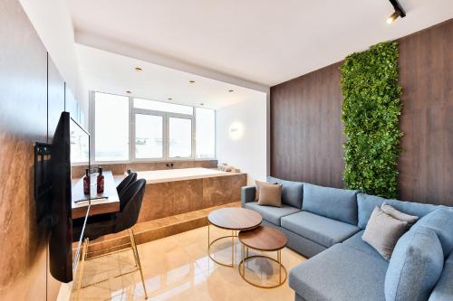 Porto Sea View Apartments في سلانيك: غرفة معيشة مع أريكة زرقاء وتلفزيون