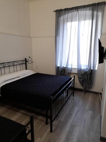 1 dormitorio con 1 cama y una ventana con cortinas en Affitta Camere La Turandot en Génova