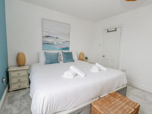 a bedroom with a large white bed with towels on it at Lyme View in Portland