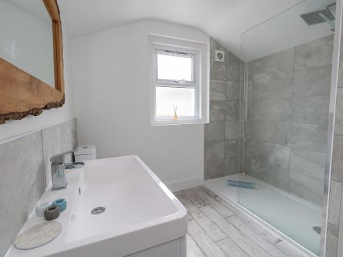 a white bathroom with a sink and a shower at Lyme View in Portland