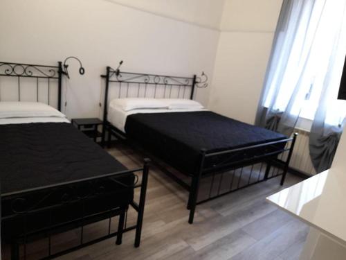 a bedroom with two beds and a window at Affitta Camere La Turandot in Genova
