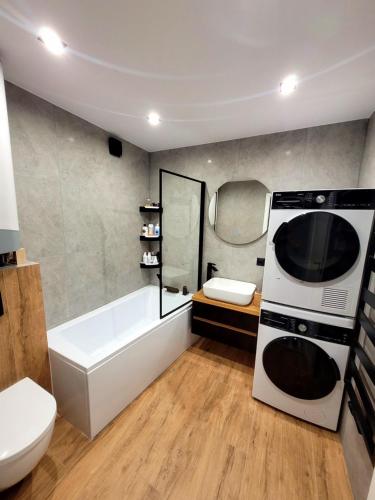 a bathroom with a white tub and a microwave at Apartament Wrzos in Cisna