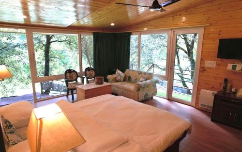 een slaapkamer met een groot bed en een woonkamer bij Dolina Retreat in Mussoorie