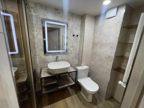 ein Badezimmer mit einem Waschbecken, einem WC und einem Spiegel in der Unterkunft Apartment VR home terrazza in Zaghkadsor