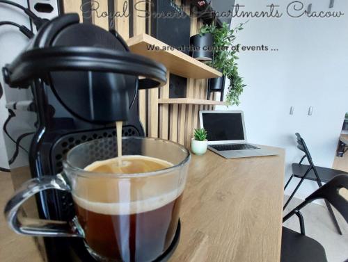 una tazza di caffè seduta sopra un bancone di Royal Smart Apartments Cracow a Cracovia