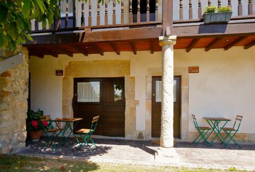 ein Gebäude mit einem Tisch und Stühlen sowie einem Balkon in der Unterkunft EL PILPAYO in Quintes