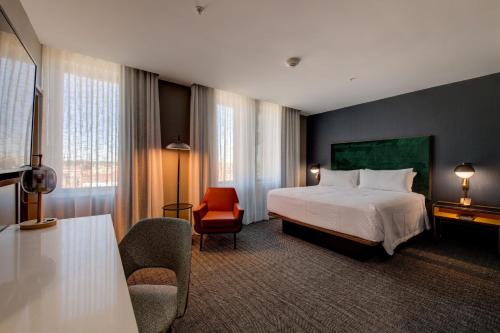 Pokój hotelowy z łóżkiem i krzesłem w obiekcie The Threefoot Hotel, Meridian, a Tribute Portfolio Hotel w mieście Meridian