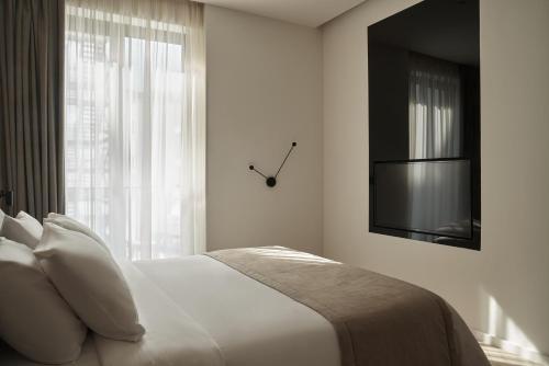 a bedroom with a bed with a tv and a window at The Newel Psychiko in Athens