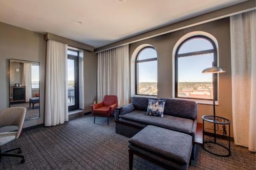 a living room with a couch and chairs and windows at The Threefoot Hotel, Meridian, a Tribute Portfolio Hotel in Meridian