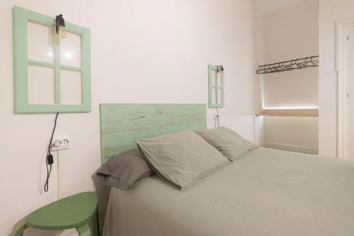 1 dormitorio con 1 cama y 1 silla verde en La Monimba, en La Laguna