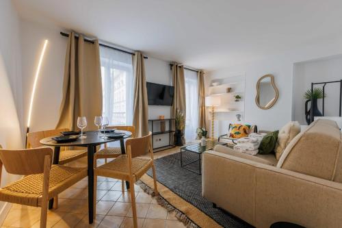 een woonkamer met een bank en een tafel bij Amazing and cosy apartment rue des Petites Ecuries 4P1BR in Parijs