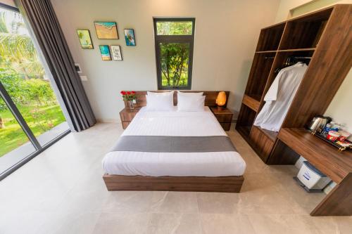 a bedroom with a bed and a large window at Emerald Garden Retreat in Phu Quoc