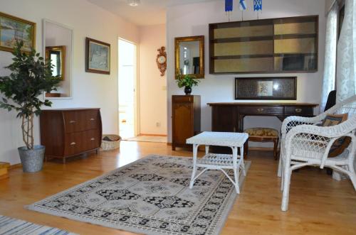 a living room with white chairs and a desk at Villa Nisula - yläkerran asunto in Teuva