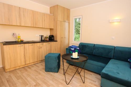 uma sala de estar com um sofá azul e uma mesa em Apartamenty na Camp4U z basenem i sauną w Siechnicach koło Wrocławia em Siechnice