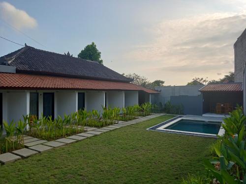 a house with a garden and a swimming pool at Parama Homestay Balangan in Uluwatu