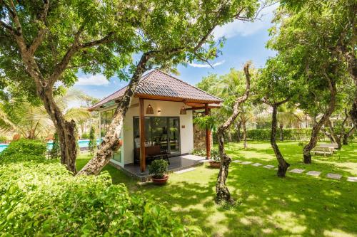 a small house in a yard with trees at Emerald Garden Retreat in Phu Quoc