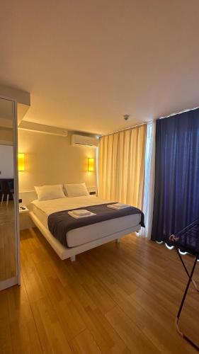 1 dormitorio con cama y cortina azul en Seaview 2 room Apartment, en Batumi