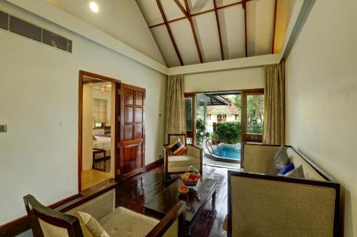 a living room with a couch and a table at Rhythm Kumarakom in Kumarakom