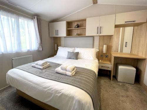 1 dormitorio con 1 cama grande y 2 toallas. en Pass the Keys Gorgeous Kippford Home With Outstanding Views, en Kippford