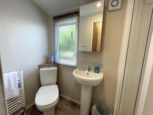 a bathroom with a toilet and a sink and a mirror at Pass the Keys Gorgeous Kippford Home With Outstanding Views in Kippford