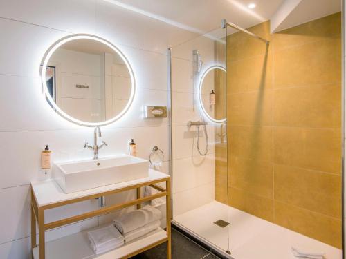 a bathroom with a sink and a shower at Hôtel Mercure Rodez Cathédrale in Rodez