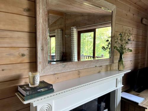 a mirror sitting on top of a fireplace in a room at Mallard Lodge - Arscott Lodges in Shrewsbury