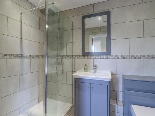 La salle de bains est pourvue d'une douche, d'un lavabo et d'un miroir. dans l'établissement Pippin Cottage, à Clacton-on-Sea