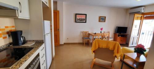 cocina y sala de estar con mesa y sillas en MU, Apartamento situada en la muralla del Casco Histórico en Villajoyosa