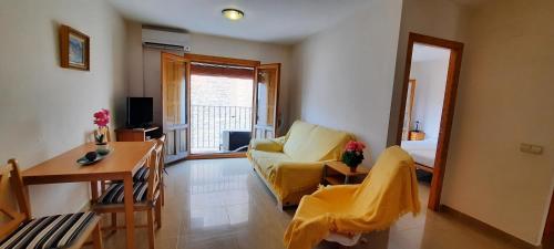 比利亞霍約薩的住宿－MU, Apartamento situada en la muralla del Casco Histórico，客厅配有黄色沙发和镜子