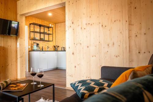 ein Wohnzimmer mit einem Sofa und einem Tisch mit Weingläsern in der Unterkunft Partnachlodge in Garmisch-Partenkirchen
