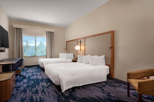 ein Hotelzimmer mit 2 Betten und einem Schreibtisch in der Unterkunft Fairfield Inn & Suites by Marriott Missoula Airport in Missoula