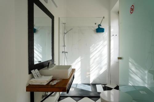 uma casa de banho com um lavatório e um espelho em Alameda Guesthouse by Boutique Taipas Garagem para motos em Portimão