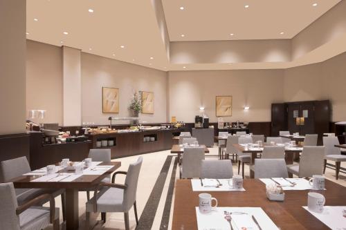 a restaurant with tables and chairs and a counter at Exe Oviedo Centro in Oviedo