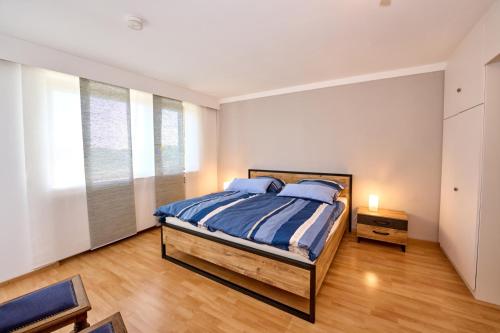 1 dormitorio con 1 cama con sábanas azules y blancas en PanoramaSicht - Daun von oben, en Daun
