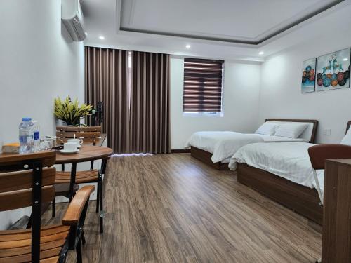 a bedroom with two beds and a table and a dining room at Starfish house in Nghi Xuân