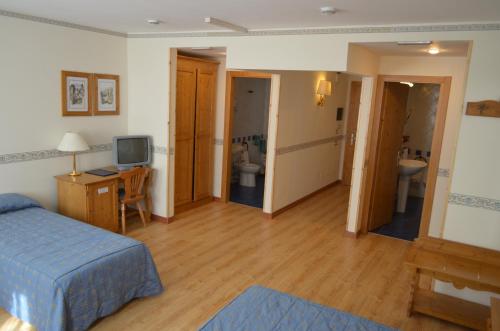 a bedroom with a bed and a desk and a bathroom at Park Hotel in Folgarida