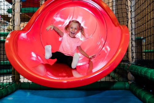 a little girl is playing on a red trampoline at Momentum Hotel in Anif