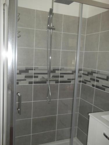 La salle de bains est pourvue d'une douche avec une porte en verre. dans l'établissement Charmante maison Lotoise, à Bretenoux