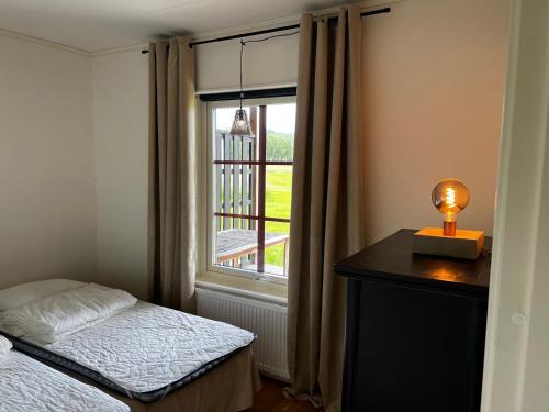 um quarto com uma cama e uma janela em Ljusnedal lägenhet med golf, paddel, fiske och skidåkning em Ljusnedal