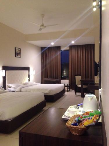 a hotel room with two beds and a table at Hotel Lake View in Saputara