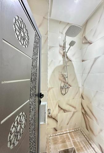 a shower with a glass door in a bathroom at Hôtel Zaghro in Ouarzazate