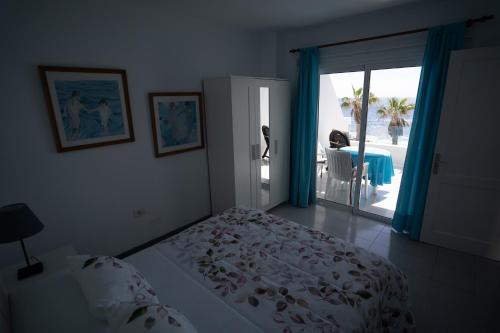 Casa La Seba في بونتا موخيريس: غرفة نوم بسرير وباب للباحة