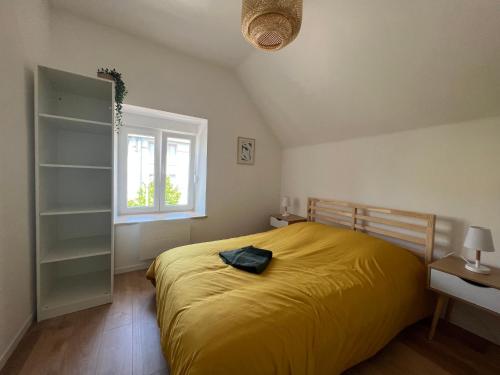 1 dormitorio con 1 cama grande de color amarillo y ventana en La Cour de Clemenceau en Montbéliard