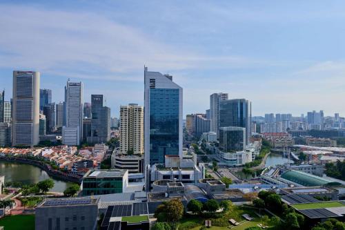 シンガポールにあるPeninsula Excelsior Singapore, A Wyndham Hotelの高層ビルと川のある街並み