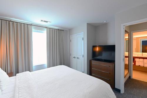 um quarto com uma cama e uma televisão de ecrã plano em Residence Inn Richmond em Midlothian
