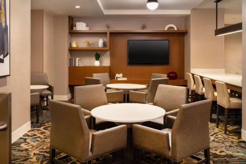 a waiting room with tables and chairs and a flat screen tv at Residence Inn by Marriott New York Manhattan/ Midtown Eastside in New York